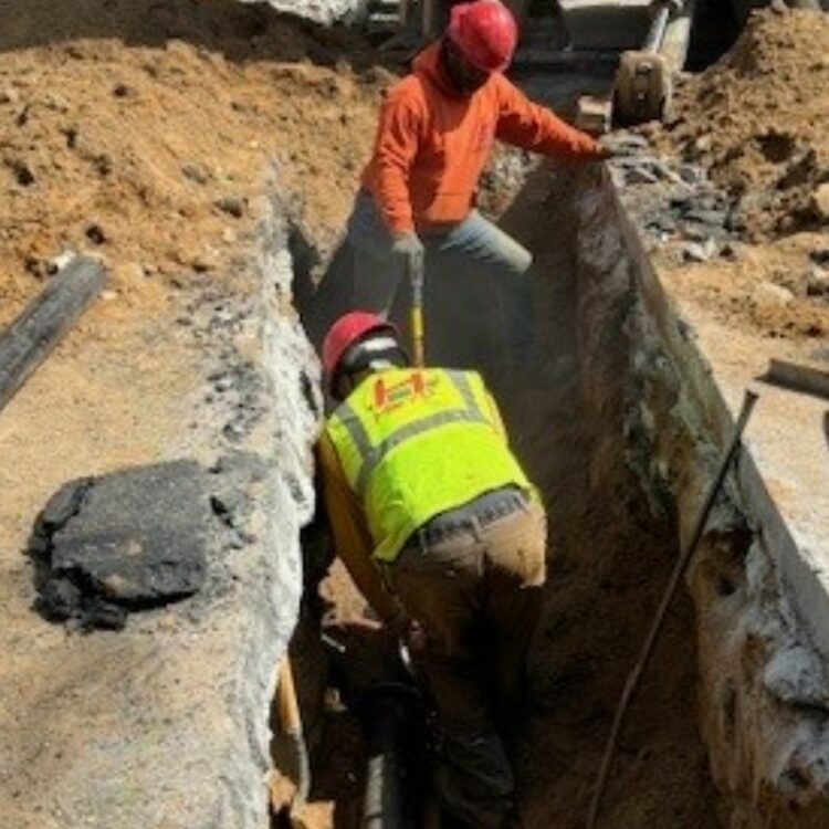 Team operating heavy-duty equipment at local worksite – alt: sewer line installation near me