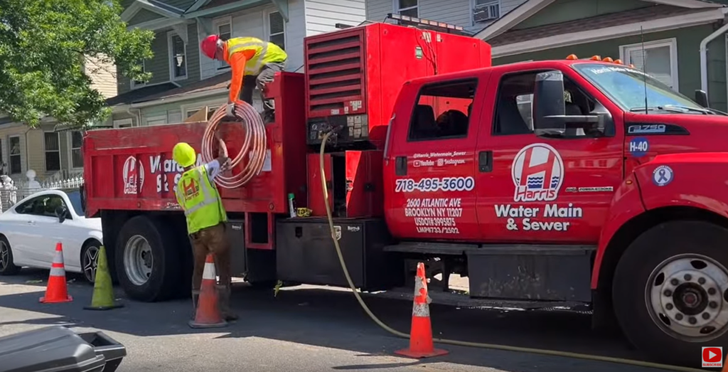 Harris Water Main & Sewer Contractors Inc service truck parked near a Manhattan building.