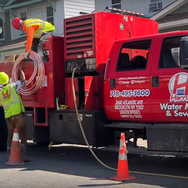 Harris Water Main & Sewer Contractors Inc service truck parked near a Manhattan building.